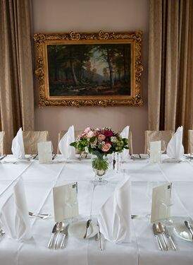 Gedeckte Tafel mit einem Gemälde im goldenen Rahmen